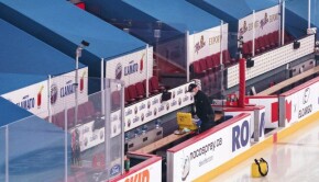 An Edmonton Oilers equipment manager clears out the team bench at the Bell Centre after the postponement of an NHL hockey game between the Montreal Canadiens and the Edmonton Oilers, in Montreal, Monday, March 22, 2021. THE CANADIAN PRESS/Paul Chiasson
