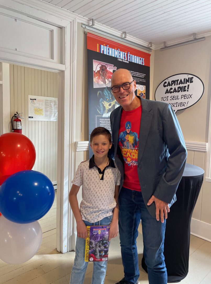 Jacob Déziel, 9 ans, le grand gagnant du concours de dessin en compagnie de Dany Bouffard. En plus d’avoir le privilège de voir son dessin illustré à l’intérieur du feuillet central de la BD : « Contact à Saint-Jacques » de Capitaine Acadie, il a reçu un lot d’albums de Capitaine Acadie, et son dessin fait partie de l’exposition.